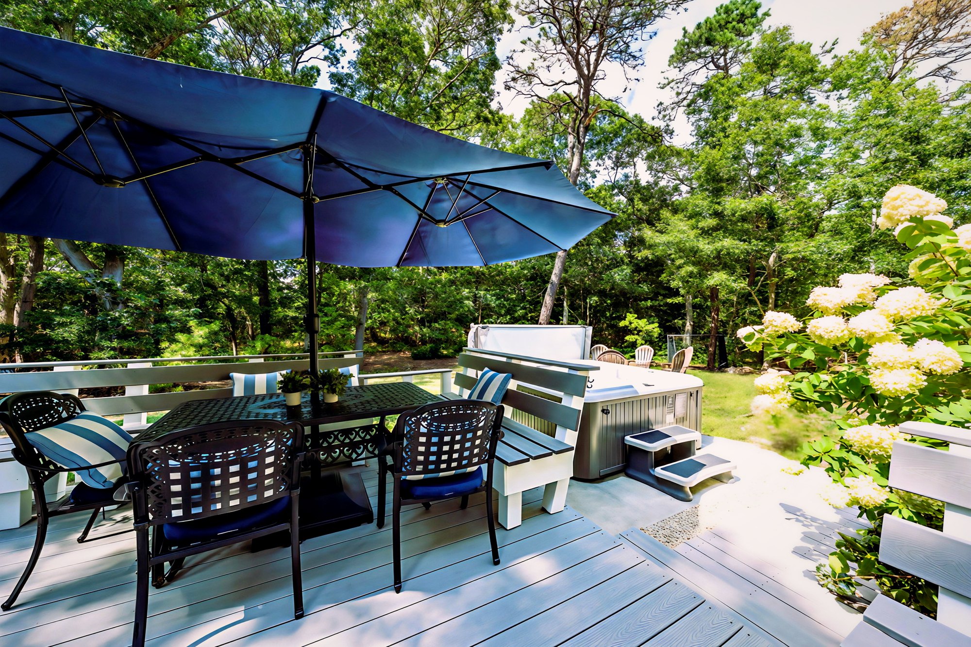 Deck dining under the umbrella beside the private hot tub and hydrangeas at Orleans Holiday House
